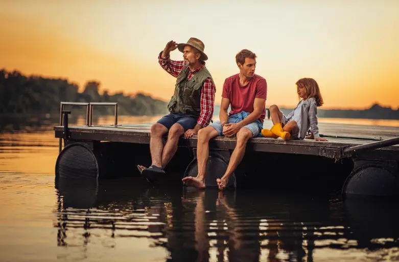 Family relaxing on pontoon at sunset