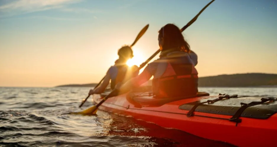 Kayaker rowing in sea